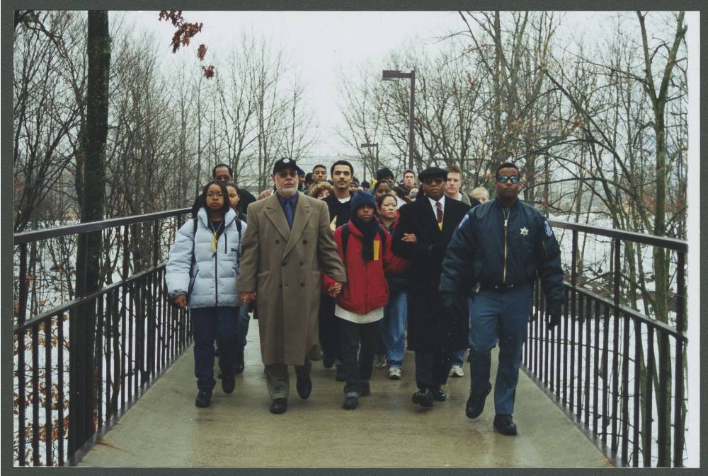 Students and family walk across the Little Mac Bridge.